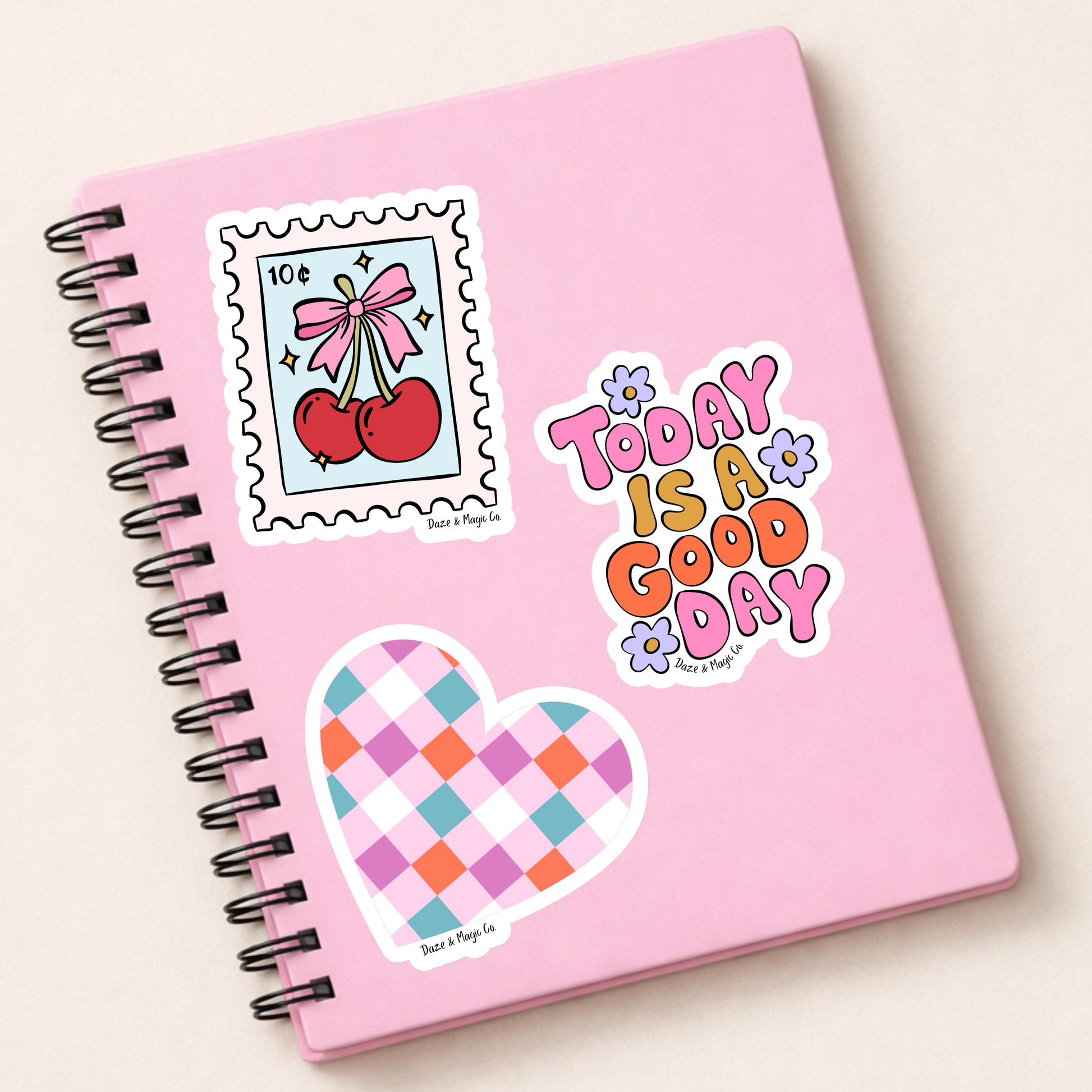 Pink notebook with decorative stickers on a light beige background