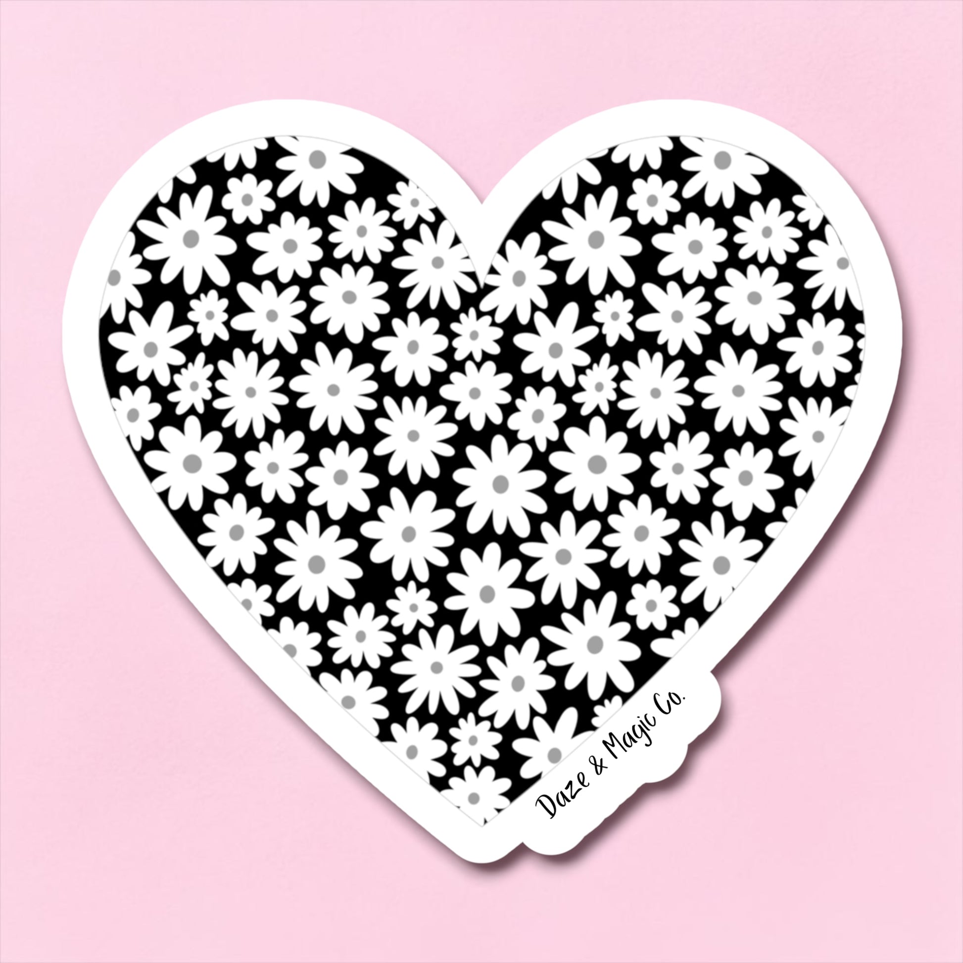 Heart-shaped sticker with black and white floral pattern on a pink background