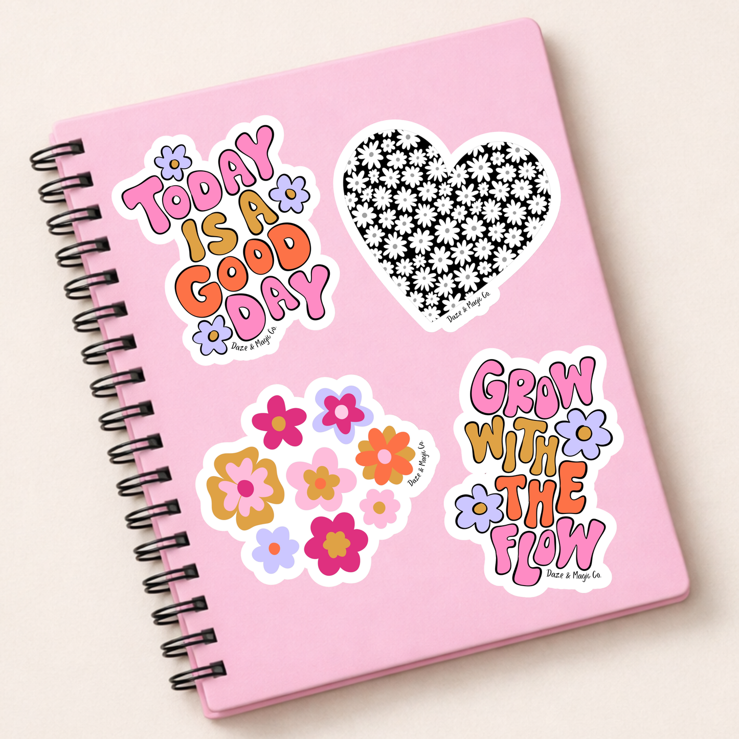 Pink notebook with decorative stickers on a light beige background