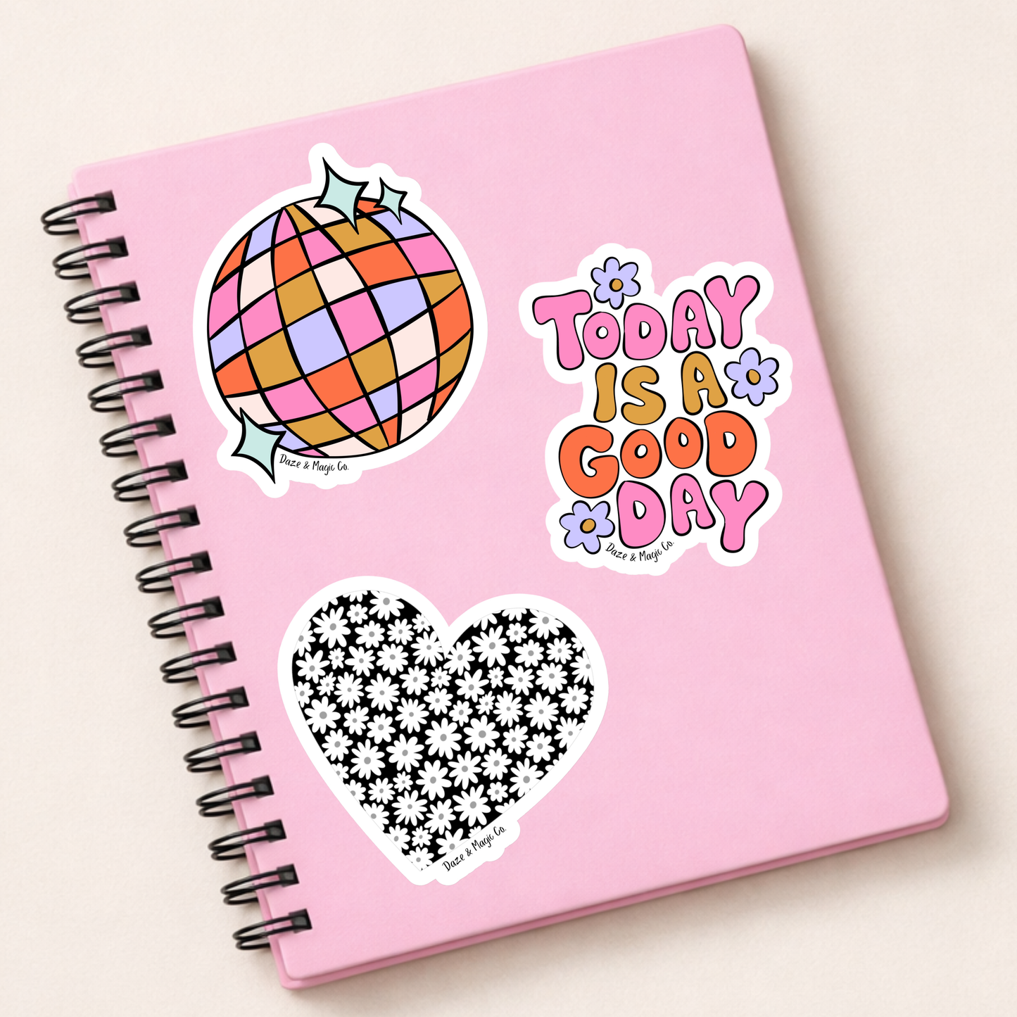 Pink notebook with stickers on a white background