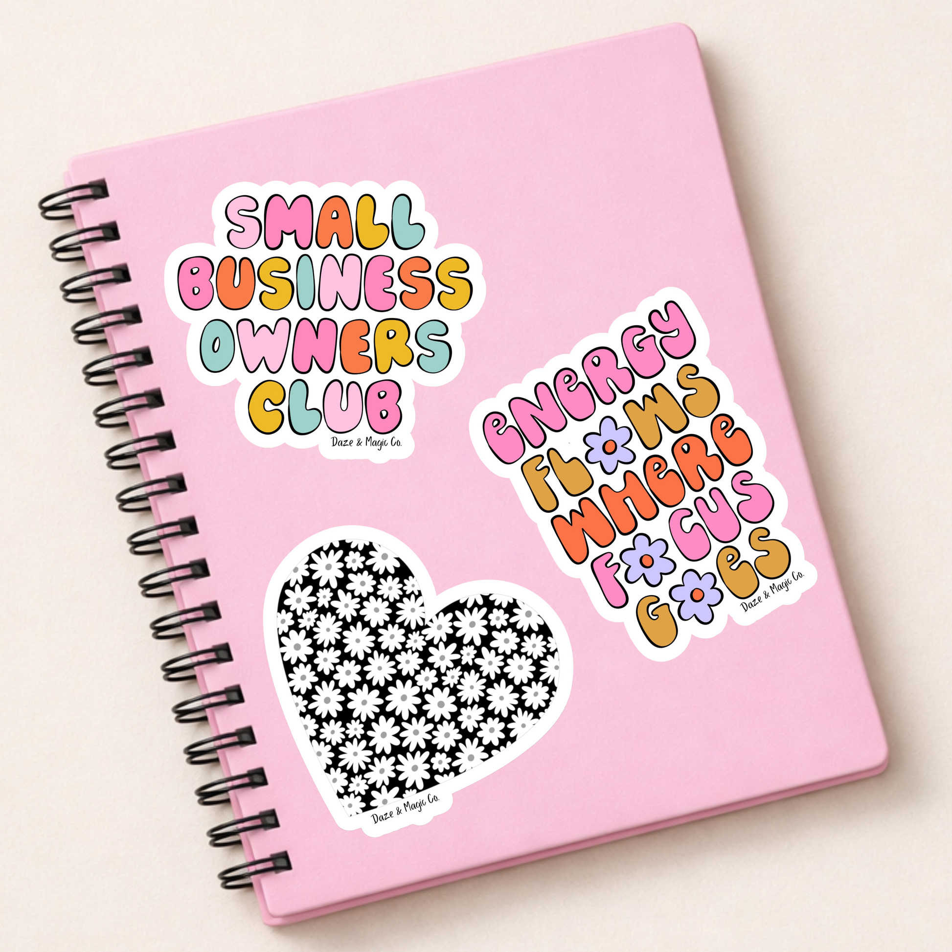Pink notebook with stickers on a light beige background