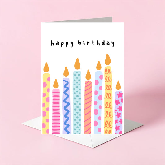Birthday card with colorful candles on a pink background