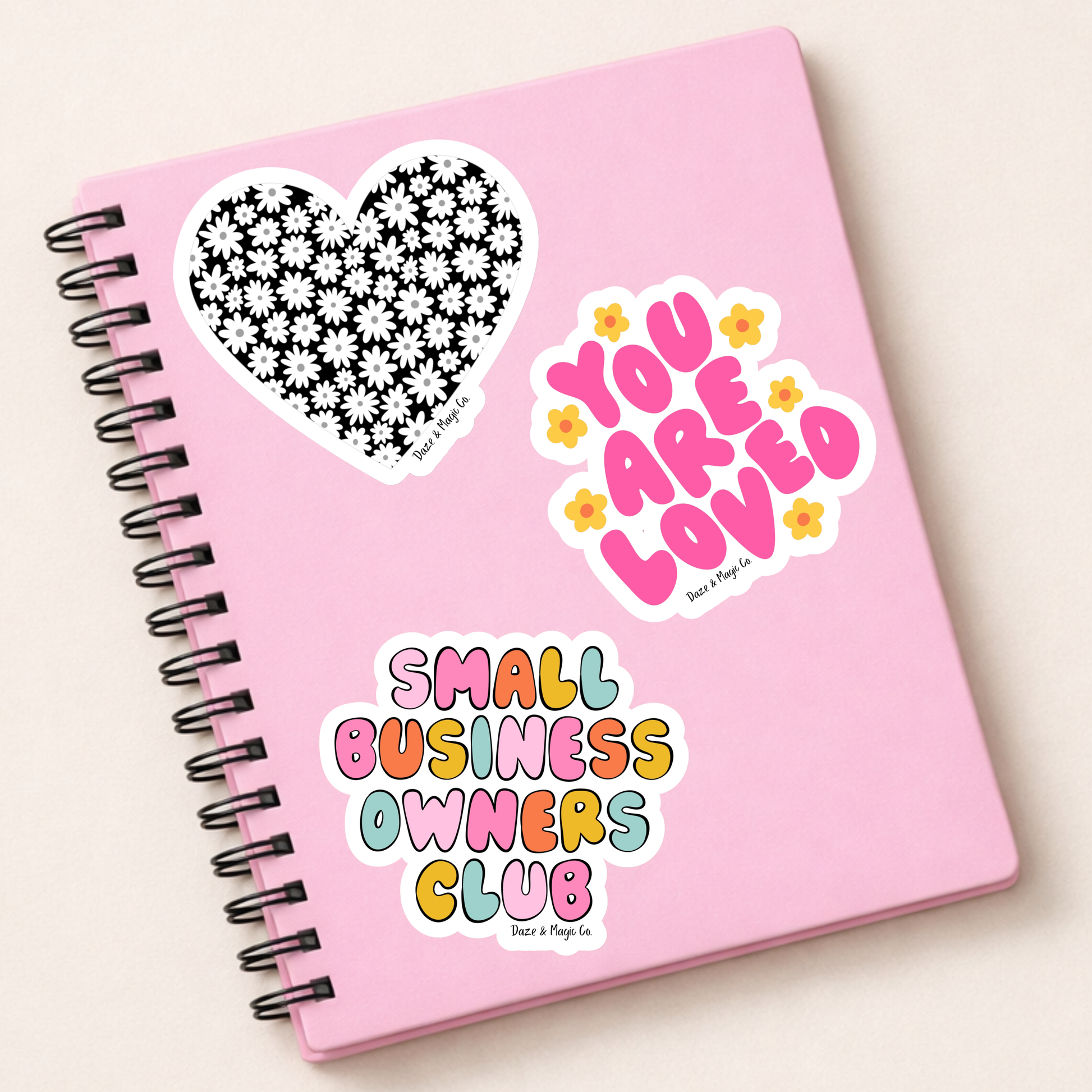 Pink notebook with decorative stickers on a light background