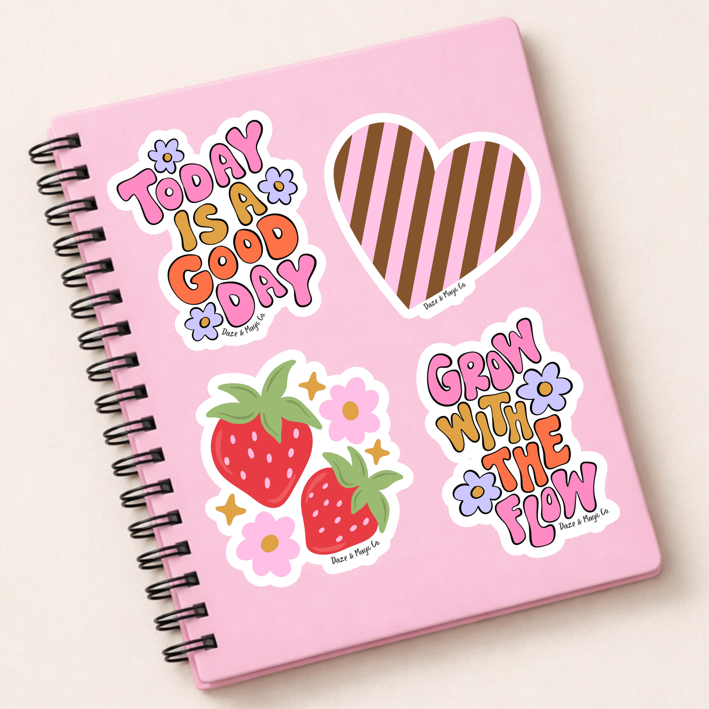 Pink notebook with decorative stickers on a light beige background